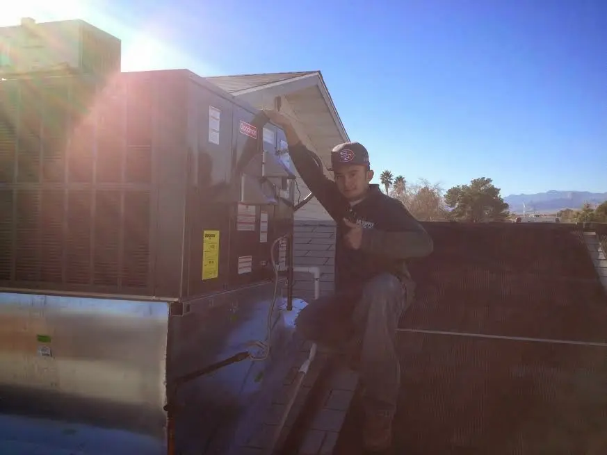 HVAC technician performing Air Duct Repair on a rooftop unit in Rocky Mount
